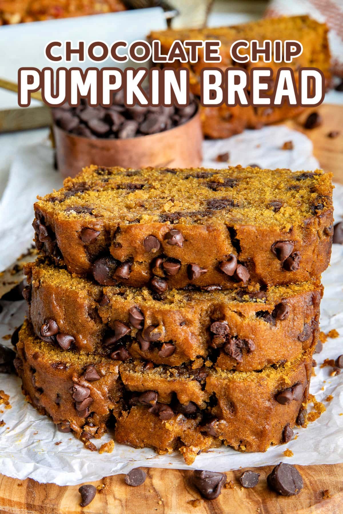 Sliced pumpkin bread filled with chocolate chips, stacked on parchment paper. The bread has a rich, moist texture with visible chocolate chips throughout. A bowl of chocolate chips is in the background, enhancing the fall-inspired dessert atmosphere. Text on the image reads 'Chocolate Chip Pumpkin Bread.
